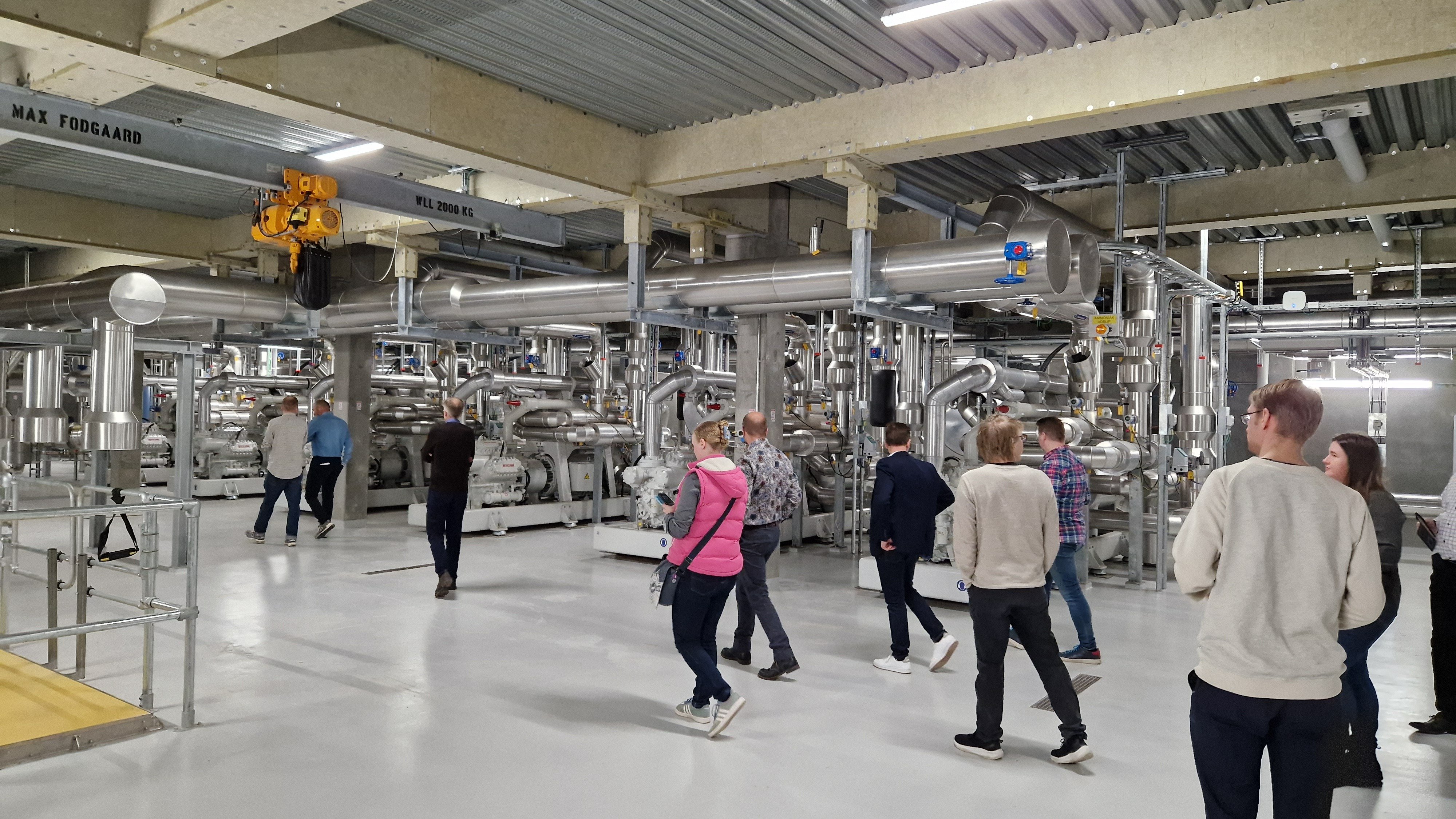 Ihmisiä kävelemässä lämpöpumppulaitoksessa.