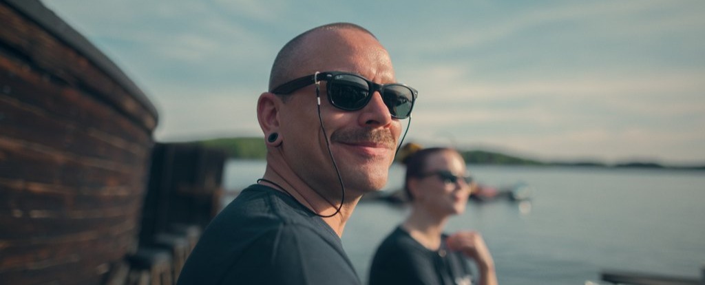 Mies ja nainen seisomassa ulkona järven rannalla.