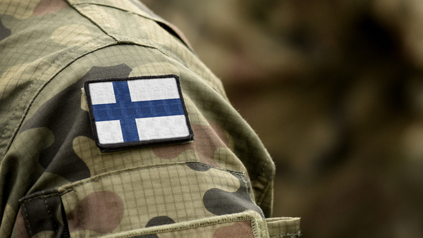 Maastopukuun kiinnitetty Suomen lippu.