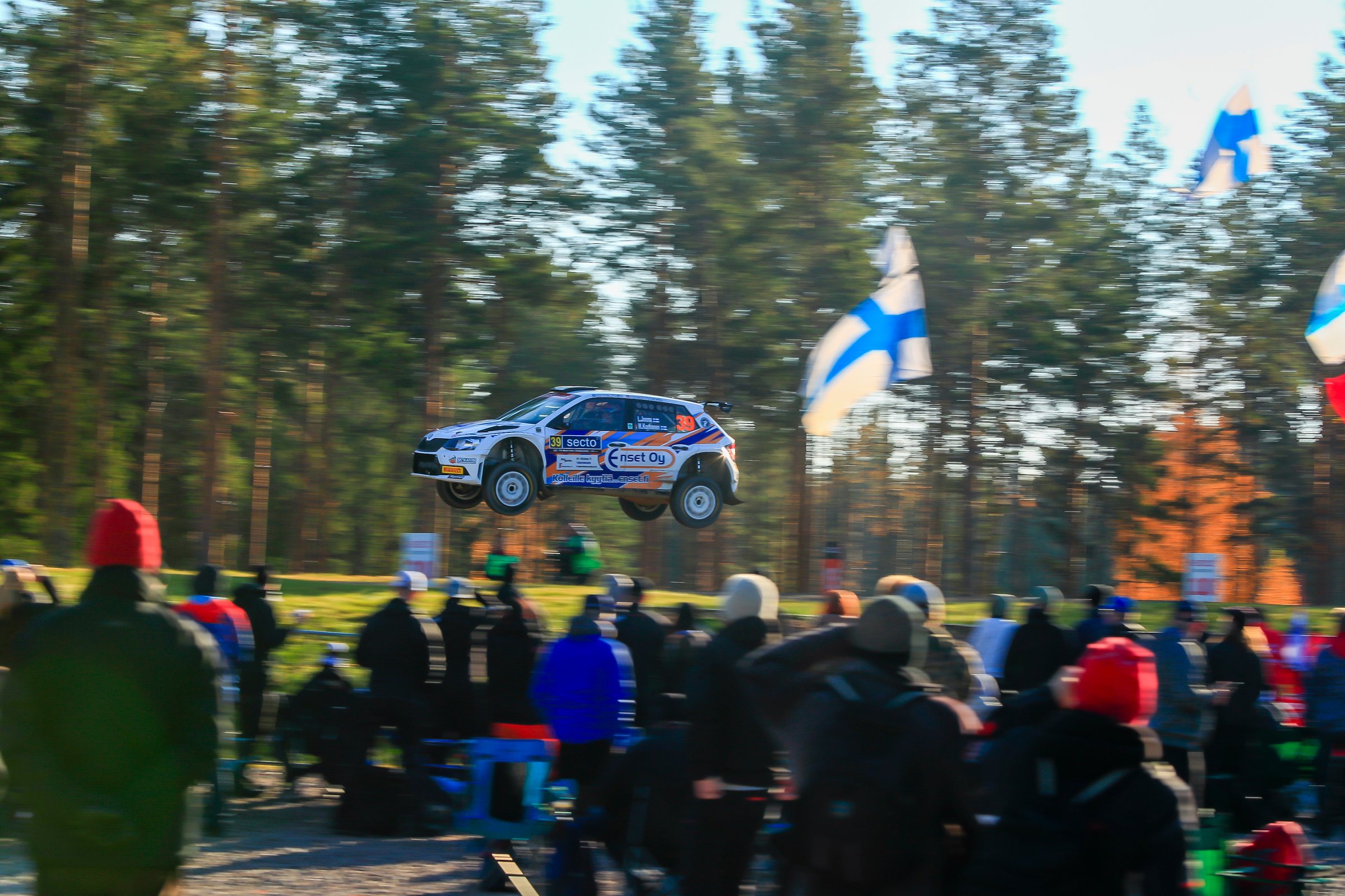 Ilmassa oleva ralliauto ja yleisöä