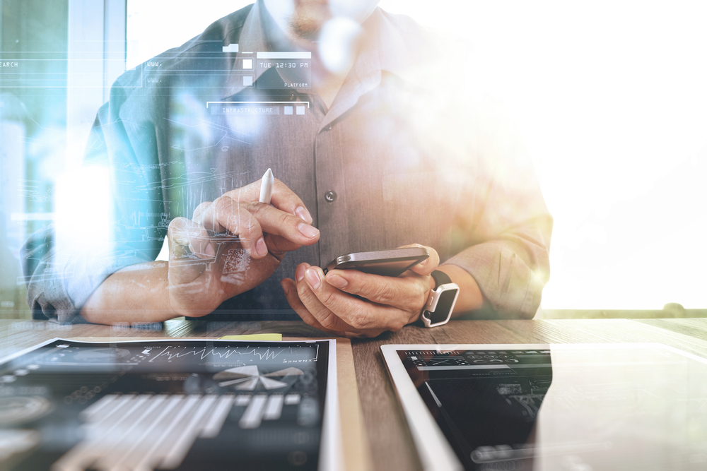 businessman working with digital tablet computer and smart phone with digital business strategy layer effect on wooden desk as concept