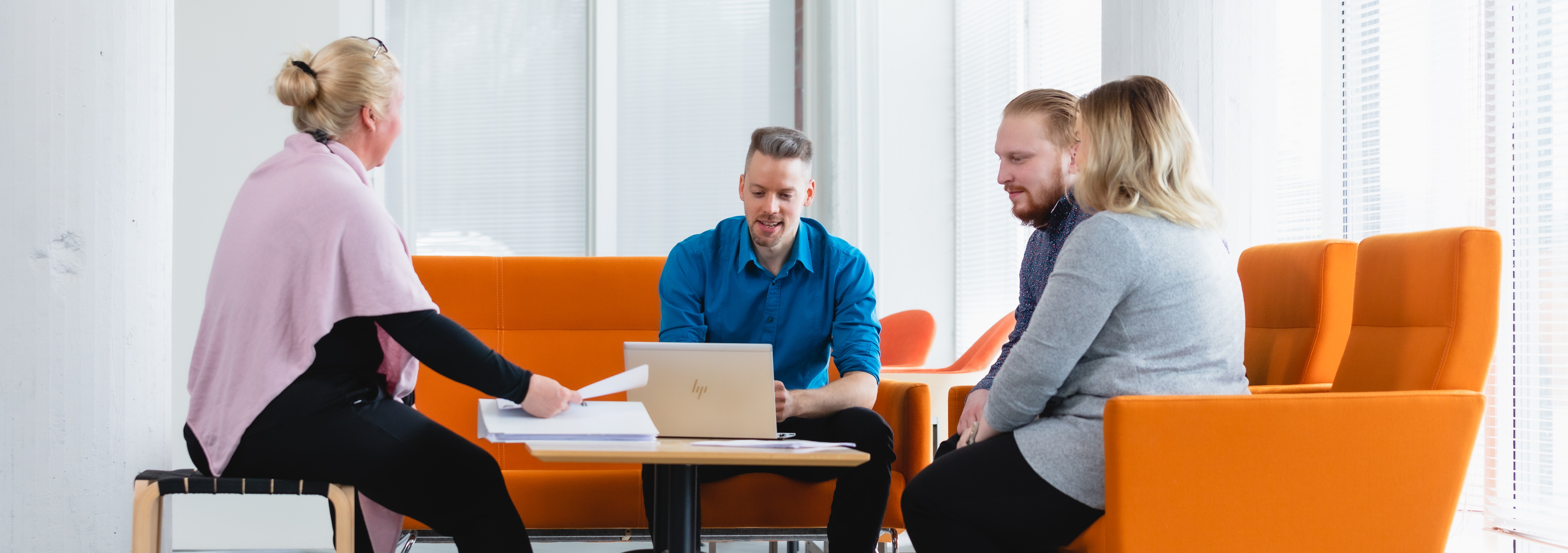 Neljä henkilöä istuu pöydän ääressä.